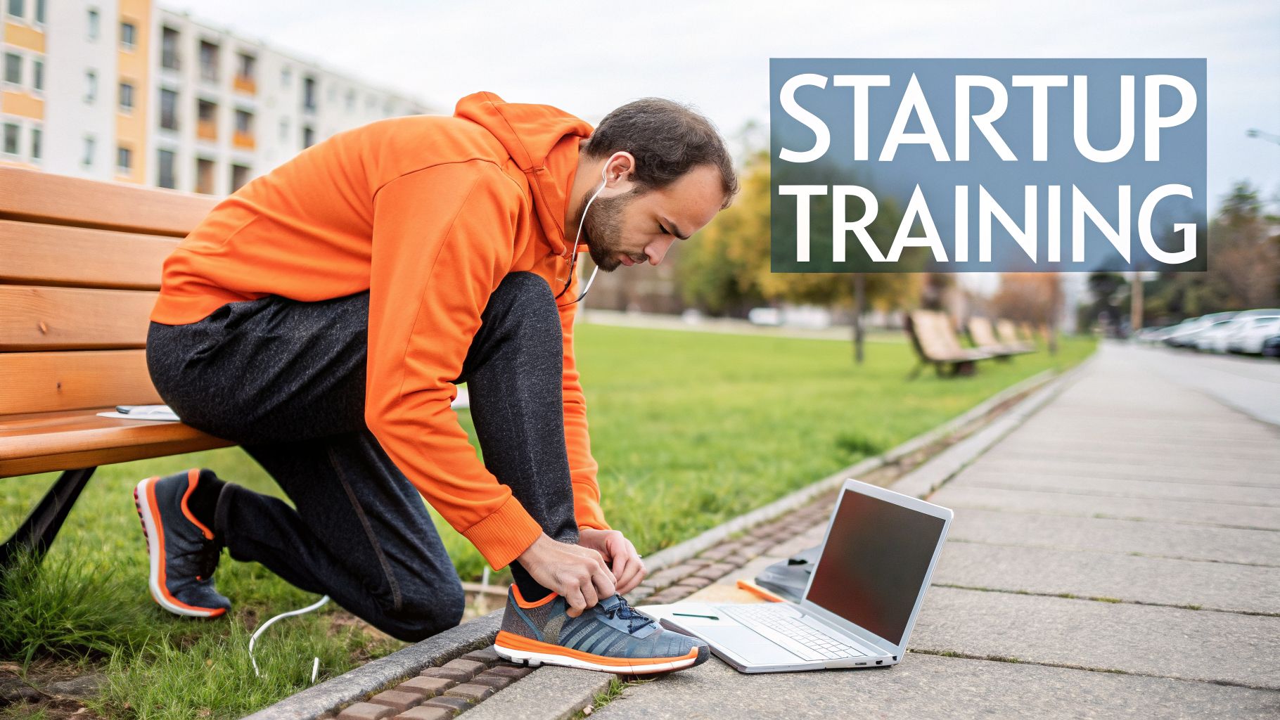 A man in an orange hoodie ties his running shoes next to a laptop with 'STARTUP TRAINING' text.