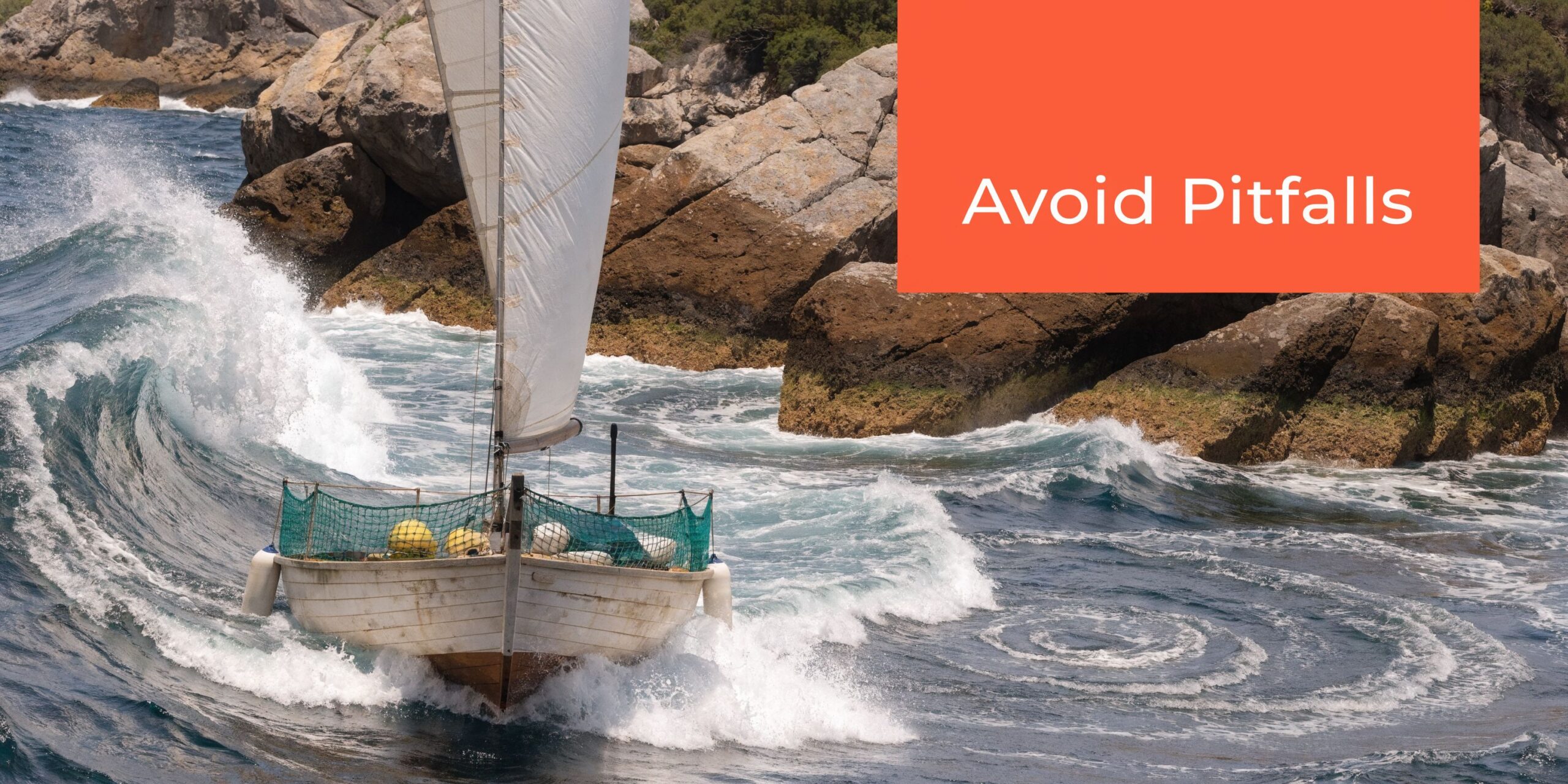 A small wooden sailboat navigating through rough, turbulent ocean waves near rocky cliffs.