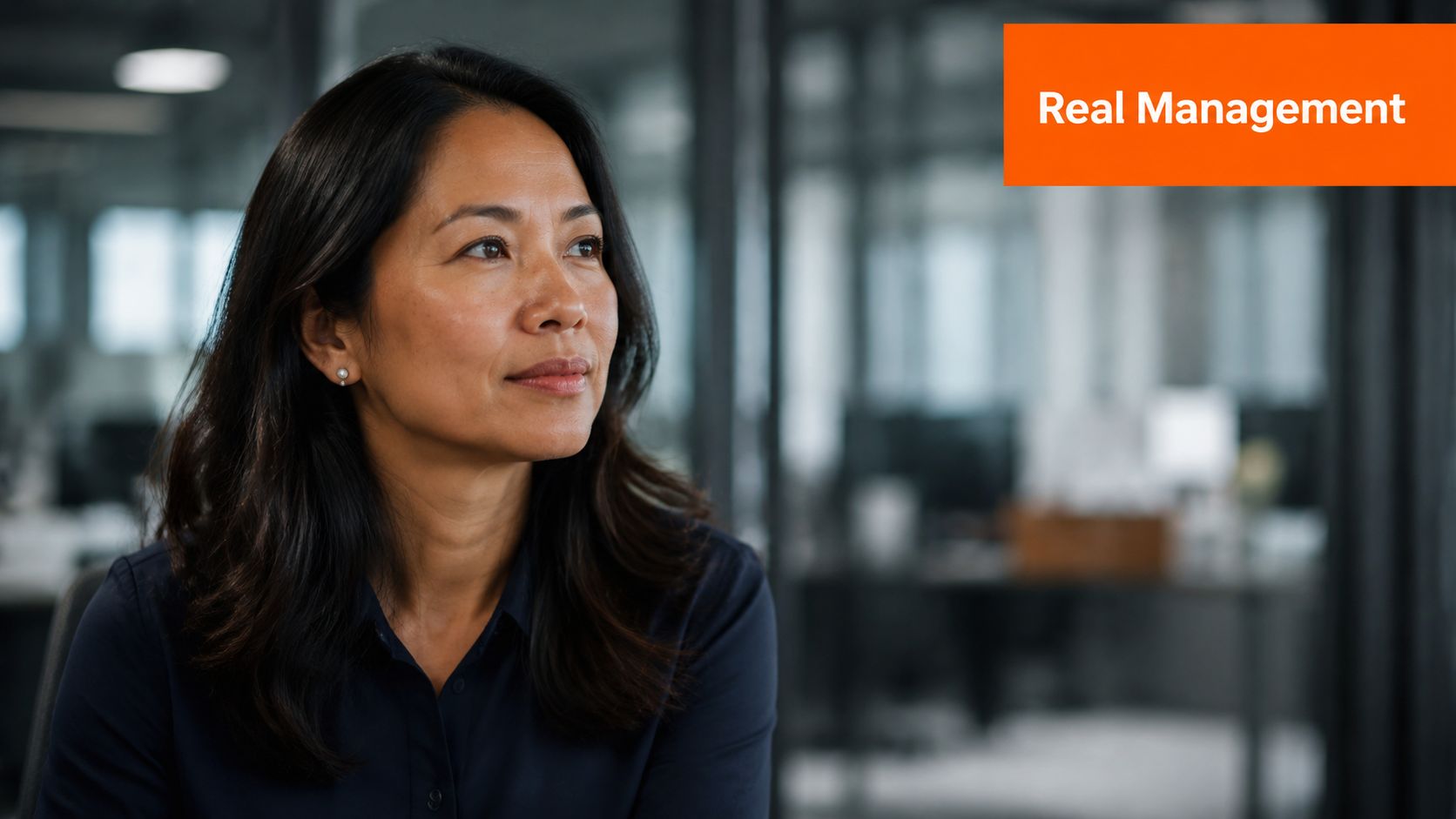 A professional woman looking thoughtful while working in a modern, blurred office environment.