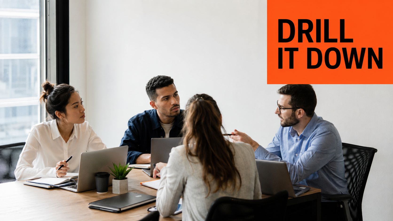 A professional team of four people collaborating around a wooden meeting table with laptops in an office.